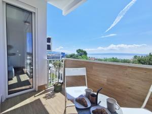 een balkon met een tafel en uitzicht op de oceaan bij Apartment Nonna in Split