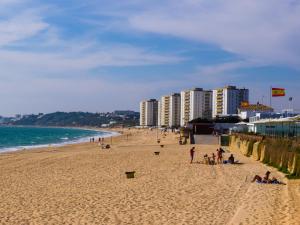 a group of people on a beach near the ocean at Hostal Costa Luz in El Puerto de Santa María