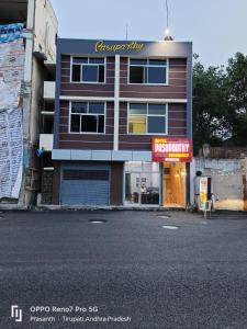 ein Gebäude mit einem Schild an der Straßenseite in der Unterkunft Hotel Pasuparthy Residency in Tirupati