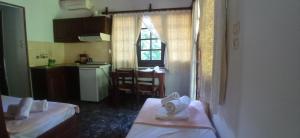 mały pokój z 2 łóżkami i kuchnią w obiekcie Guesthouse To kalivi w mieście Chorefto