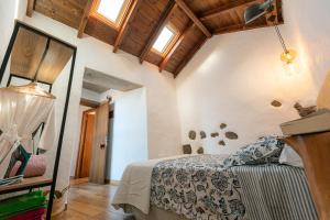 una camera da letto con un letto in una stanza con soffitti in legno di La Candia y el Mar a Valverde Altre 26 foto