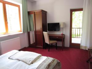 Willa M cisza w centrum miasta في كرينيتسا زدروي: غرفة نوم بها سرير ومكتب مع تلفزيون