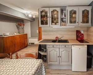 a kitchen with white cabinets and a sink in a room at Le Clos de Vitermont in Englebelmer