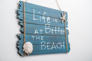 a sign that says life is at better the beach at Island Life in Mali Lošinj
