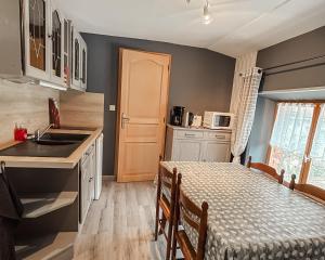 eine Küche mit einem Tisch und einem Waschbecken in einem Zimmer in der Unterkunft Le Clos de Vitermont in Englebelmer
