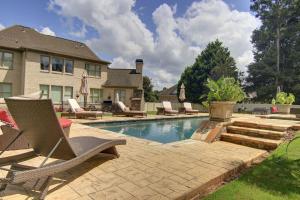 a backyard with a swimming pool with chairs and a house at The REZORT-Ideal for Exclusive Events Feat. Pool, Gym, Fire Pit & More! in Lawrenceville
