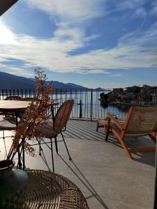 een patio met een tafel en stoelen en uitzicht op het water bij Trizonia Mare Suites in Trizonía
