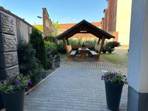 エアフルトにあるFerienwohnungen in Erfurtのピクニックテーブルとパビリオン付きの庭園