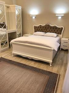 um quarto com uma grande cama branca e uma grande cabeceira de cama. em Garden House Uzungöl em Uzungol