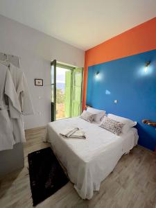 a bedroom with a large bed with an orange wall at Blue Horizon Kastellorizo in Meyisti