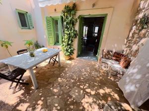 邁伊斯蒂的住宿－Blue Horizon Kastellorizo，房屋内带桌子和沙发的庭院