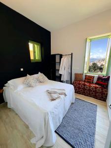 1 dormitorio con cama blanca y pared negra en Blue Horizon Kastellorizo, en Meyisti