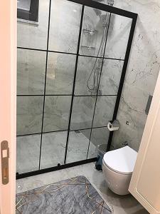 a bathroom with a glass shower door with a toilet at Garden House Uzungöl in Uzungol