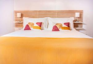 een slaapkamer met een groot wit bed met kleurrijke kussens bij Suite indipendente su due livelli (metro B Libia) in Rome