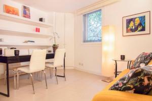een woonkamer met een tafel en witte stoelen bij Suite indipendente su due livelli (metro B Libia) in Rome