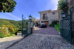 une porte menant à une maison avec une voiture garée dans l'allée. dans l'établissement Casa do Avô, à Entre-os-Rios