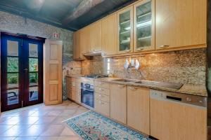 a large kitchen with wooden cabinets and a door at Casa do Avô in Entre-os-Rios