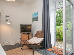 a living room with a chair and a television at Headland Cottages in Coverack