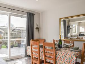 a dining room with a table and chairs and a mirror at Markham House in Radipole