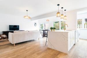 eine weiße Küche und ein Wohnzimmer mit einem Sofa in der Unterkunft Oeiras Apartment in Oeiras