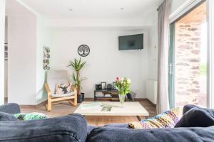 a living room with a couch and a table at La grange de Merlin in Concoret