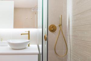 ein Badezimmer mit Dusche und weißem Waschbecken in der Unterkunft Oeiras Apartment in Oeiras