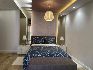 a bedroom with a bed with a black and white comforter at Villa i SPA Stević in Veliko Gradište