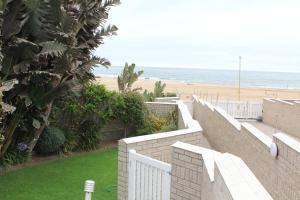 a white fence with a beach in the background at Muller's Self Catering - a cozy home from home! in Swakopmund