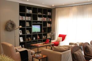 a living room with couches and a large book shelf at Muller's Self Catering - a cozy home from home! in Swakopmund