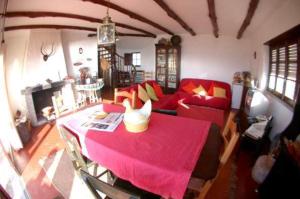 a living room with a red table and a couch at CASA DAS PONTES in Ribamar