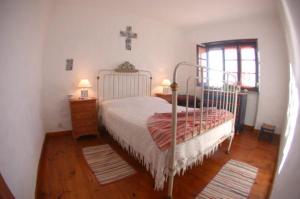 a bedroom with a bed and a cross on the wall at CASA DAS PONTES in Ribamar