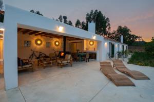 a large outdoor patio with chairs and a fireplace at Monte Esmeralda in São Luis