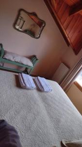 - une chambre avec un lit et un miroir mural dans l'établissement Roca, à San Martín de los Andes