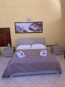 a bedroom with a large bed with towels on it at CASE VACANZA ZOE - SOLE in Serrano