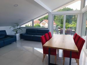 a dining room with a table and red chairs at Luxury Family Apartment with Terrace FRIGO in Maribor