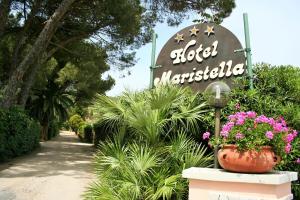 a sign for a hotel with flowers in a pot at Hotel Maristella in Cavo