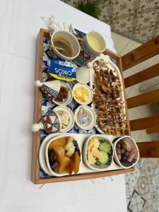 マーディアにあるHotel Dar Al Madinaのテーブルの上に様々な種類の食料を詰めたトレイ