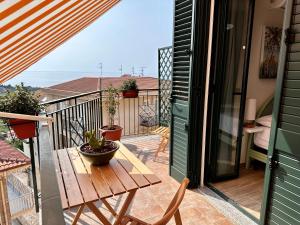 een balkon met een houten tafel en een tafel bij Amuka B&B in Santo Stefano di Camastra