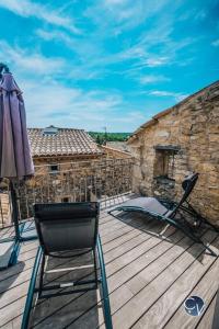 taras z parasolem, krzesłem i parasolem w obiekcie Maison de village cosy avec terrasse privée w mieście Saint-Marcel-de-Carreiret