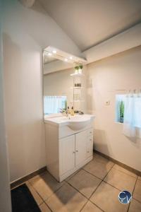 łazienka z umywalką i lustrem w obiekcie Maison de village cosy avec terrasse privée w mieście Saint-Marcel-de-Carreiret