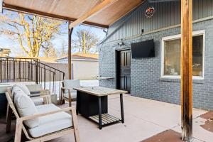 a patio with chairs and a table and a tv at New Colorful Home - Backyard Oasis - City Park in Denver