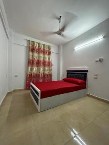 a bedroom with a bed with a red blanket and a curtain at مبيت Mabeet - شقق ستديو in 6th Of October