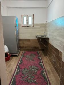 a bathroom with a sink and a red rug at مبيت Mabeet - شقق ستديو in 6th Of October
