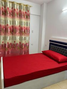 a bedroom with a red bed with a curtain at مبيت Mabeet - شقق ستديو in 6th Of October