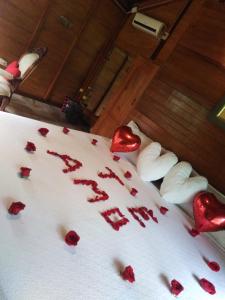 una cama con corazones rojos en las sábanas en Estancia La Colina, en Santo Domingo de los Colorados