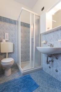 uma casa de banho com um chuveiro, um WC e um lavatório. em Cà Masawalsa Hotel em Bardolino