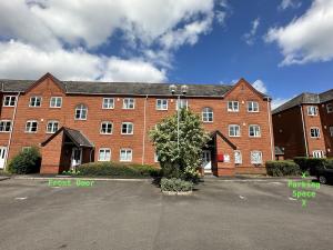 a large brick building with a tree in a parking lot at No24 - 2-bed Boutique Apartment - Hosted by Hutch Lifestyle in Leamington Spa
