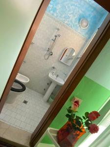 ein Badezimmer mit einem Waschbecken, einem WC und einem Waschbecken in der Unterkunft Albergo Acapulco in Bellaria-Igea Marina