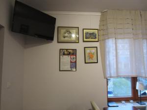 Willa M cisza w centrum miasta في كرينيتسا زدروي: غرفة معيشة فيها تلفزيون وصور على الحائط