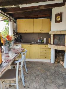 une cuisine avec des armoires jaunes, une table et des chaises dans l'établissement Casa Martina, à Alexandroúpolis